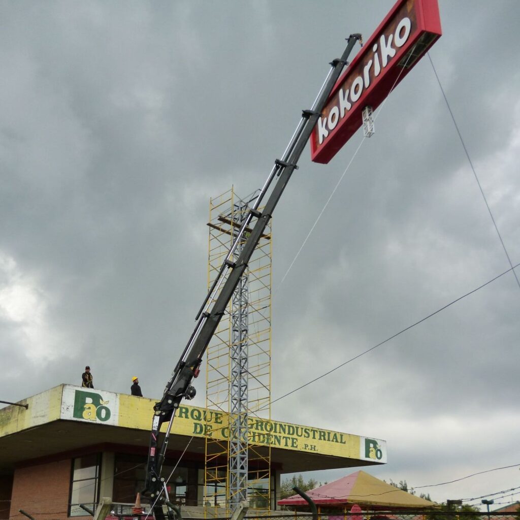 Grúa con aviso de Kokoriko. Proceso de instalación de aviso en Colombia.